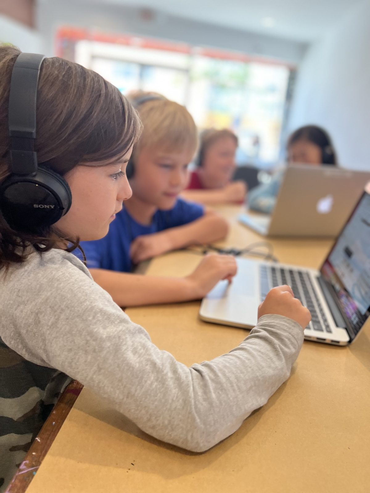 Students working together on laptops during a hands-on learning session
